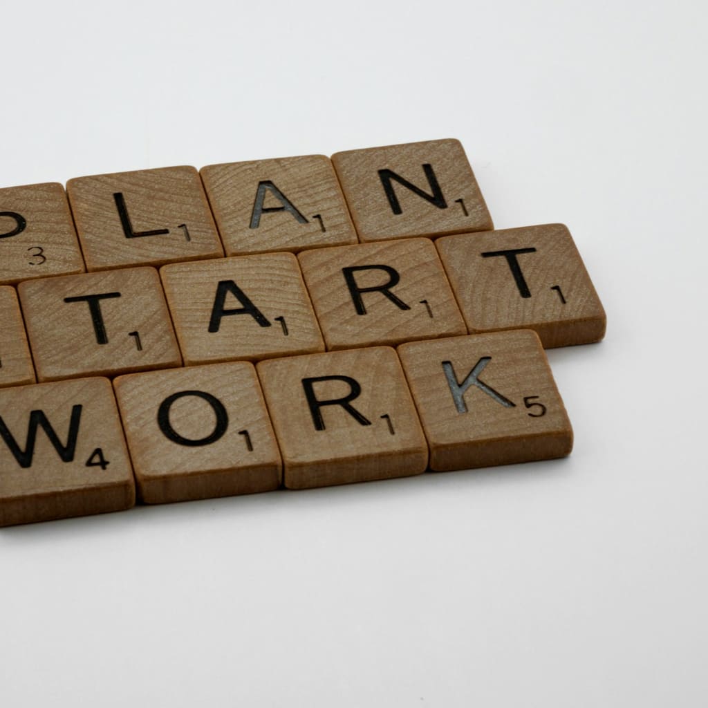 Letter tiles spelling the words plan, start, and work.